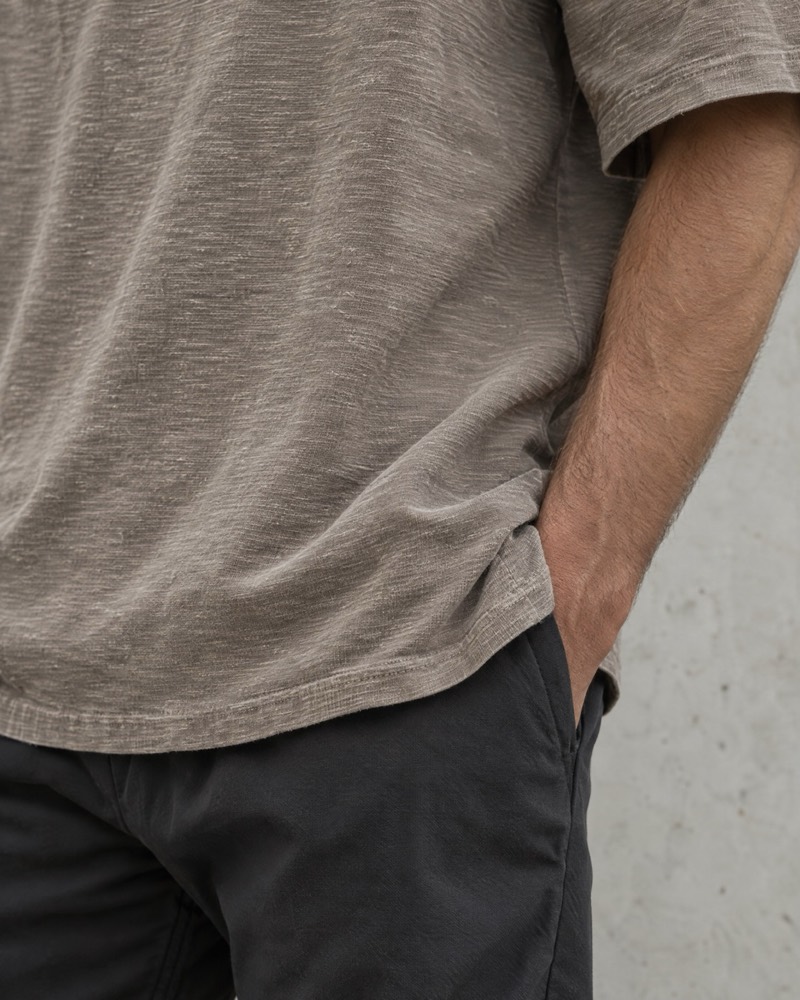 The hem of an oversized washed taupe slub tee